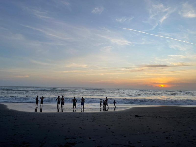 Players relaxing on the beach at sunset